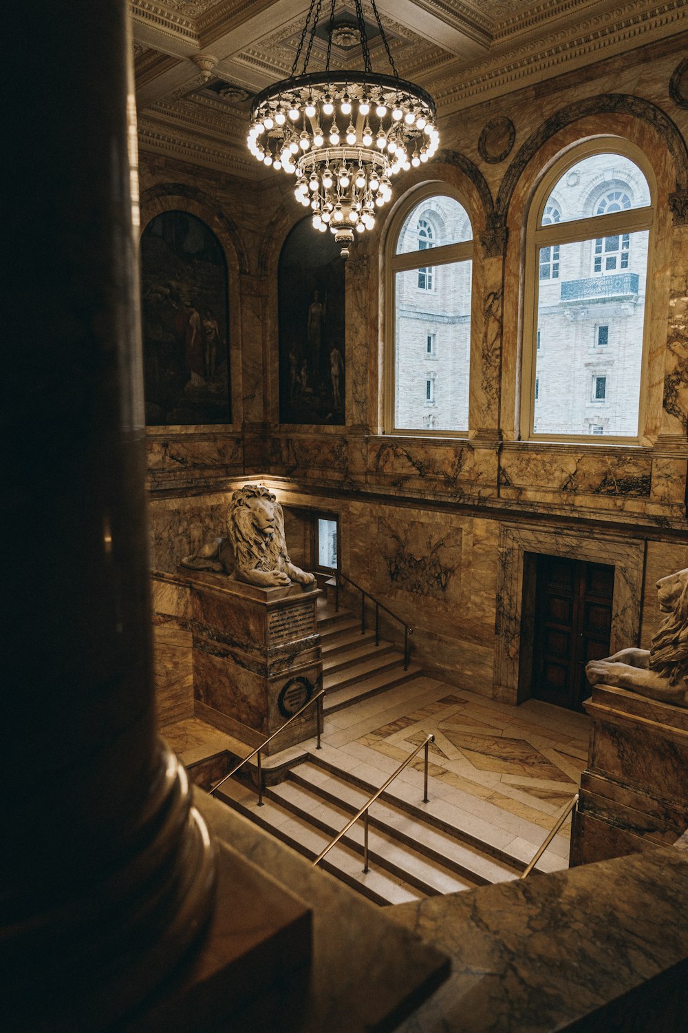 une grande salle avec un lustre et des marches en marbre