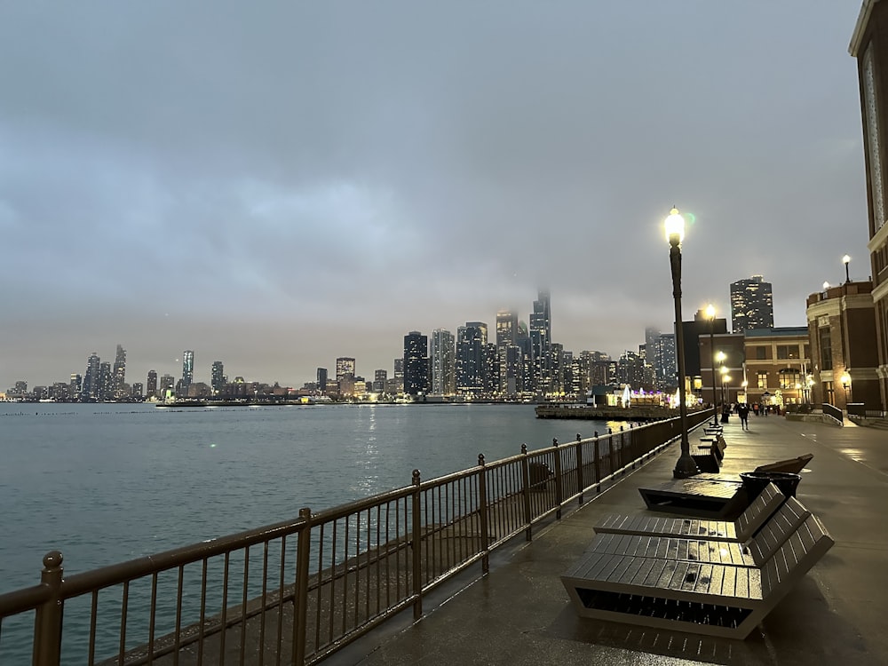 a city skyline is seen in the distance from a pier