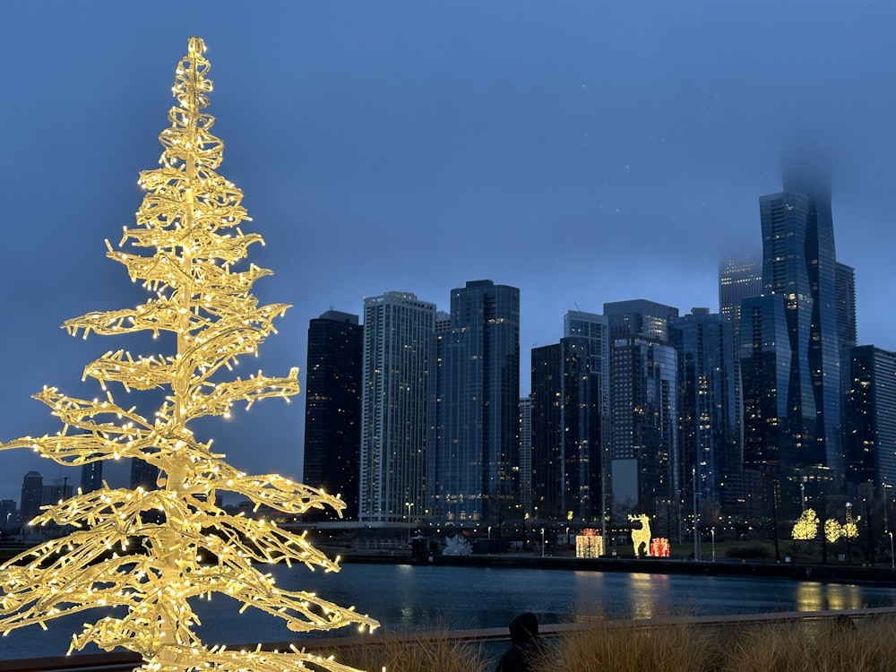 a lighted christmas tree in front of a city skyline