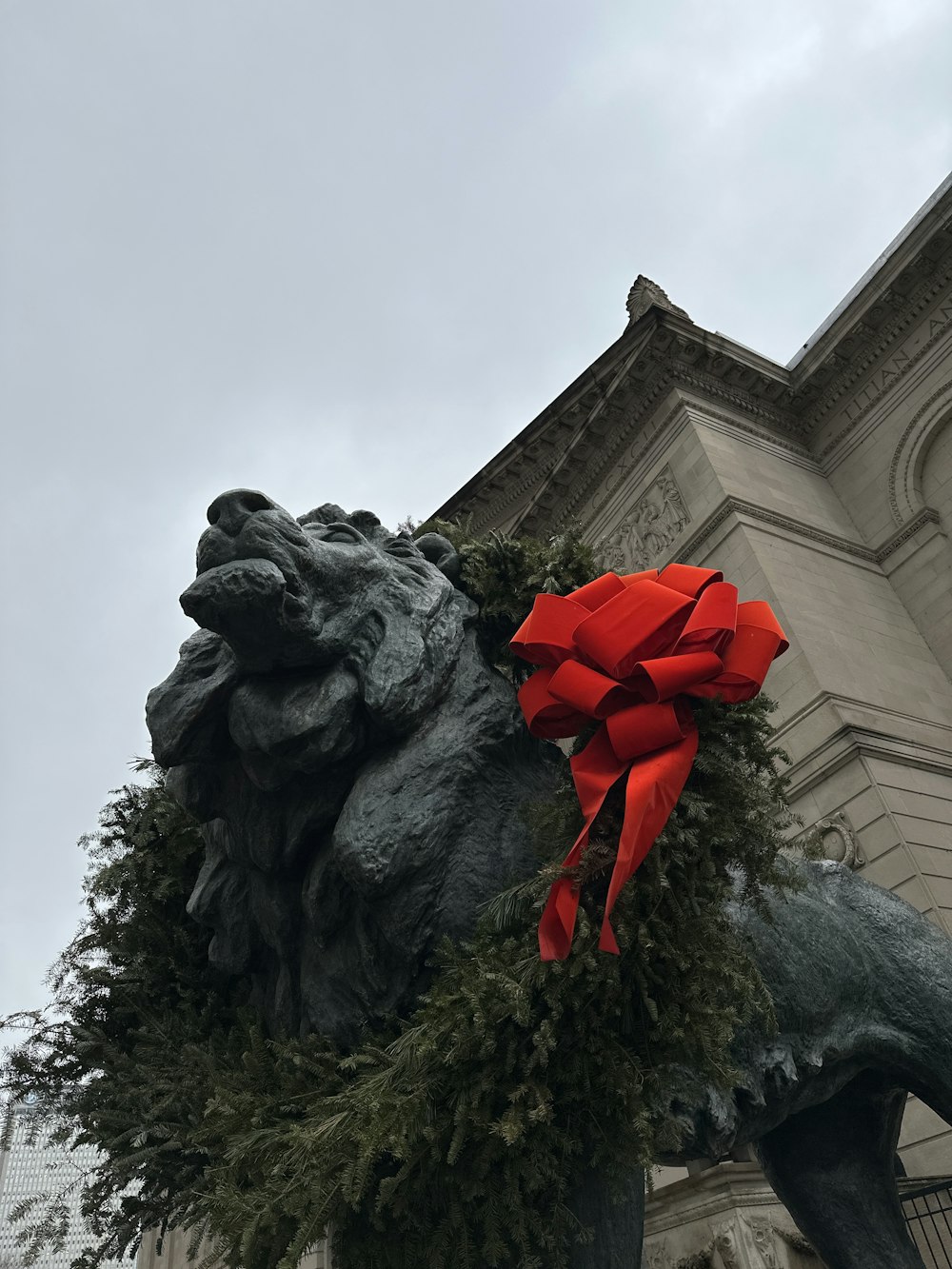 a statue of a lion with a red bow around its neck