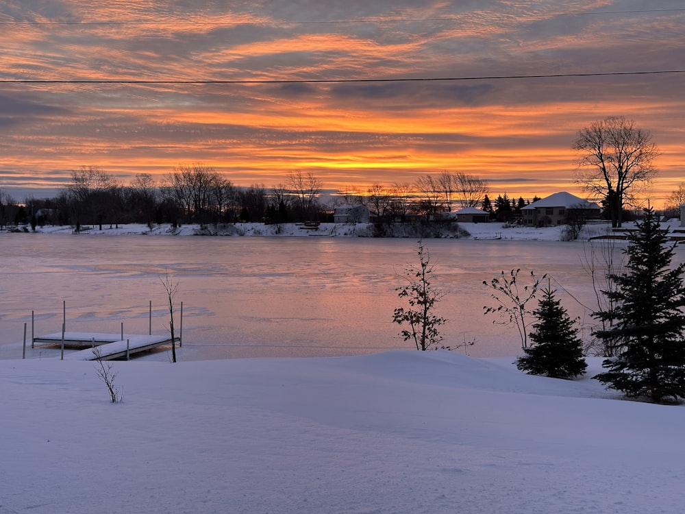 the sun is setting over a frozen lake