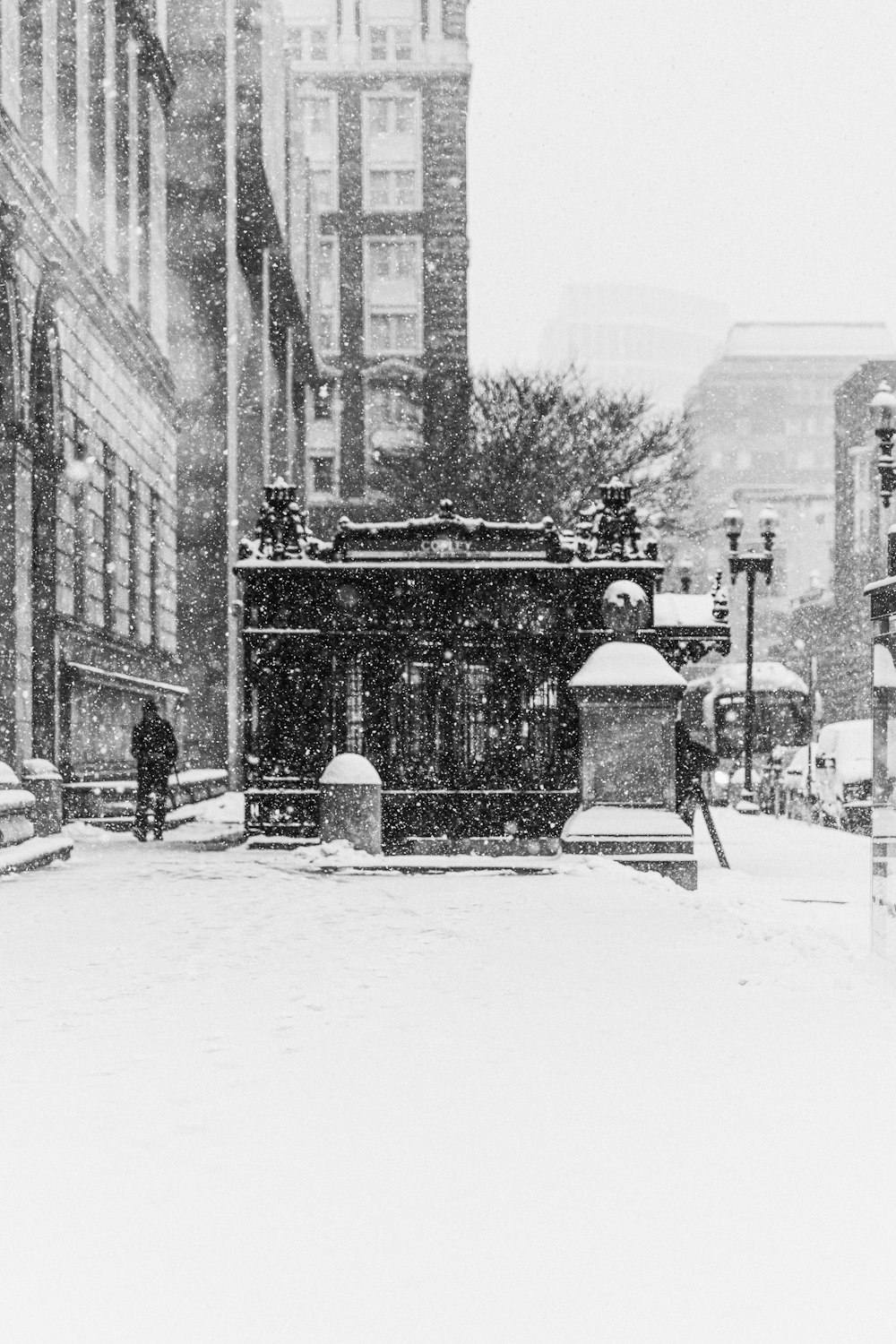 a black and white photo of a snowy street