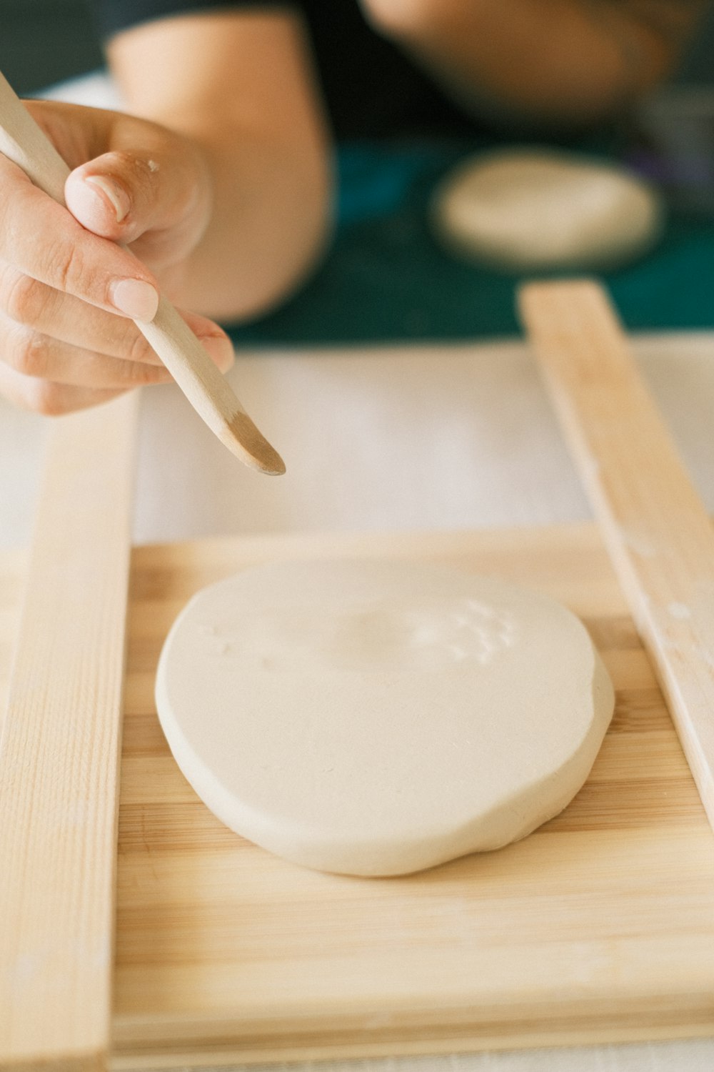 a person using a knife to cut a piece of wood