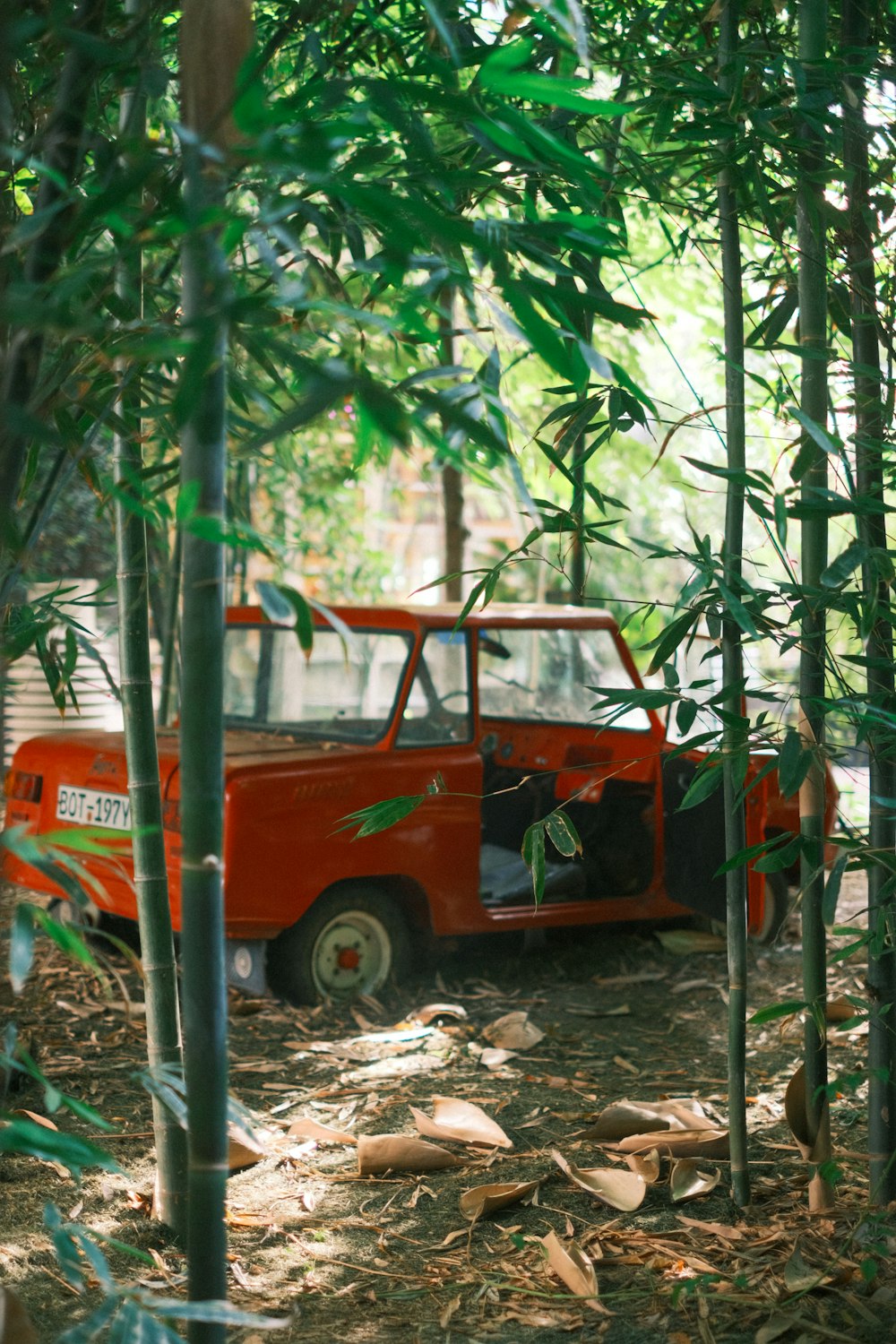 an orange truck parked in the middle of a forest