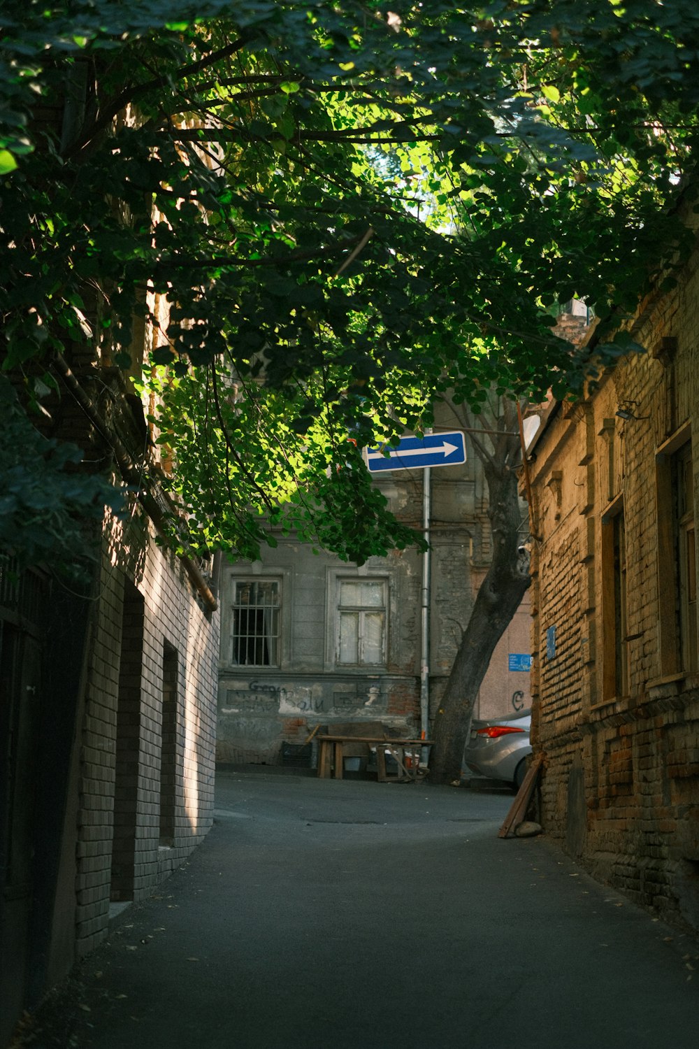 a narrow alley way with a blue street sign