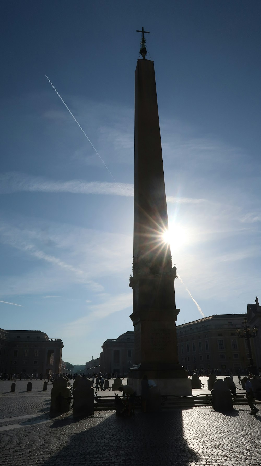 the sun is shining behind a tall monument