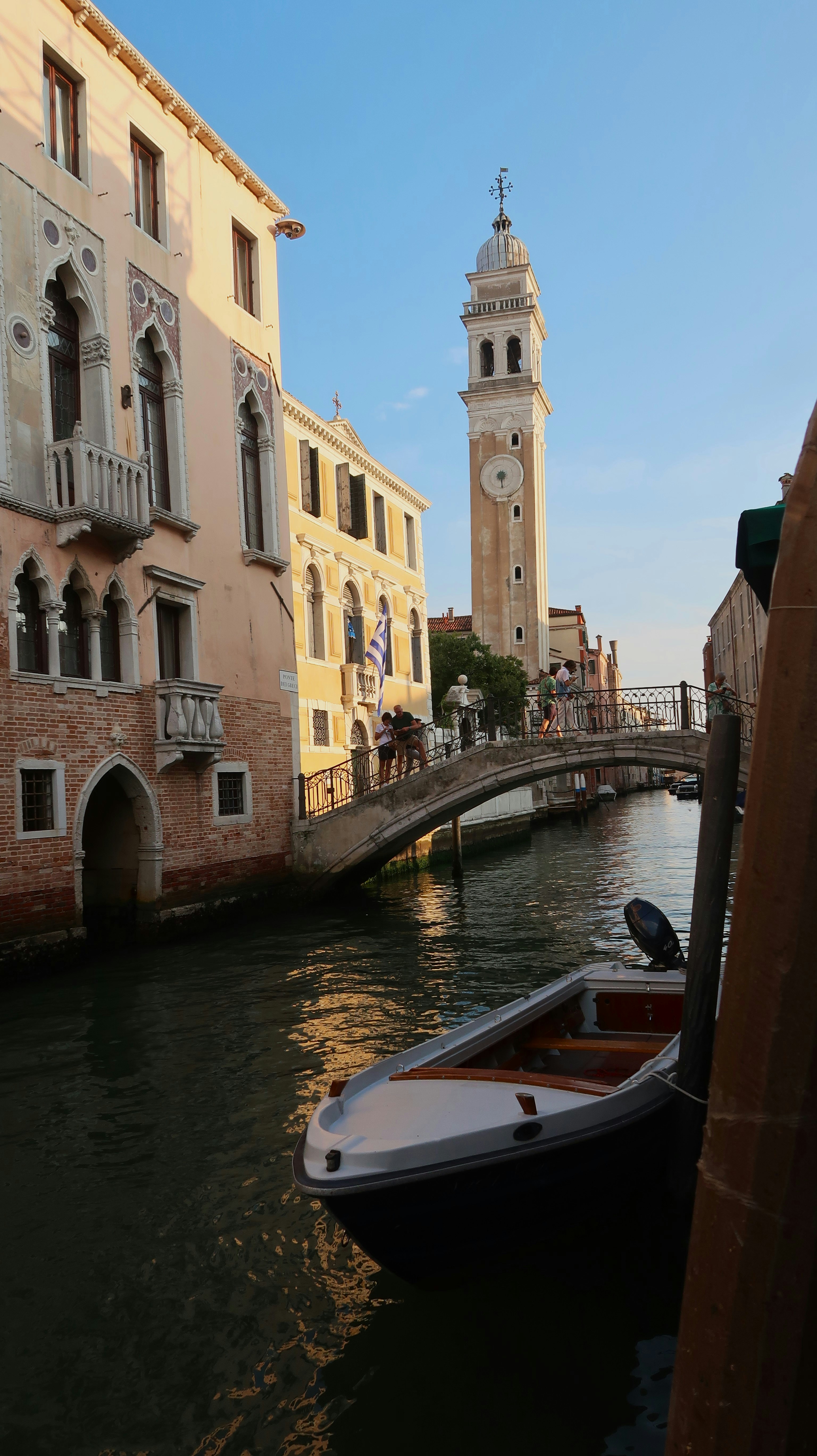 a small boat floating down a river next to tall buildings