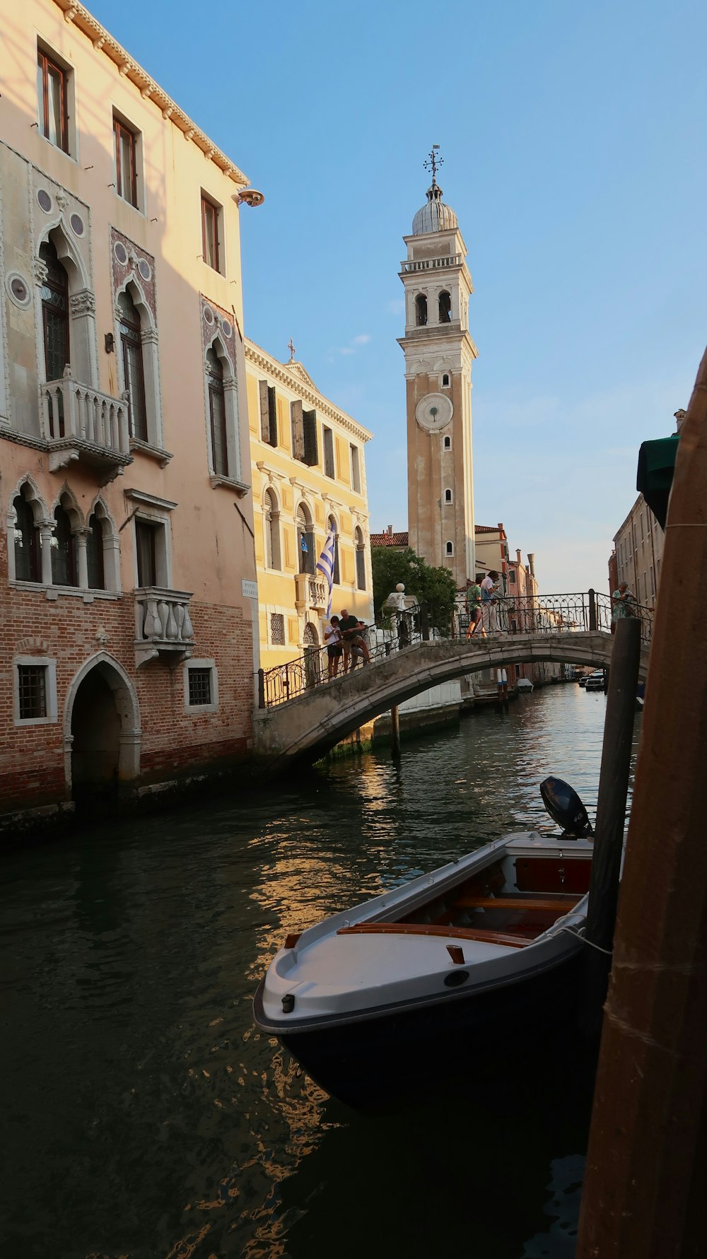 a small boat floating down a river next to tall buildings