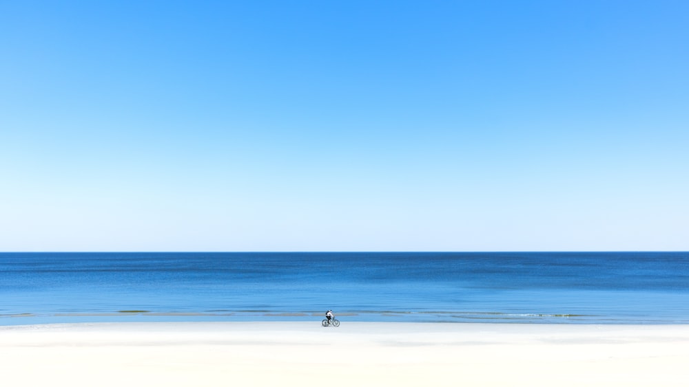 a person standing on a beach next to the ocean