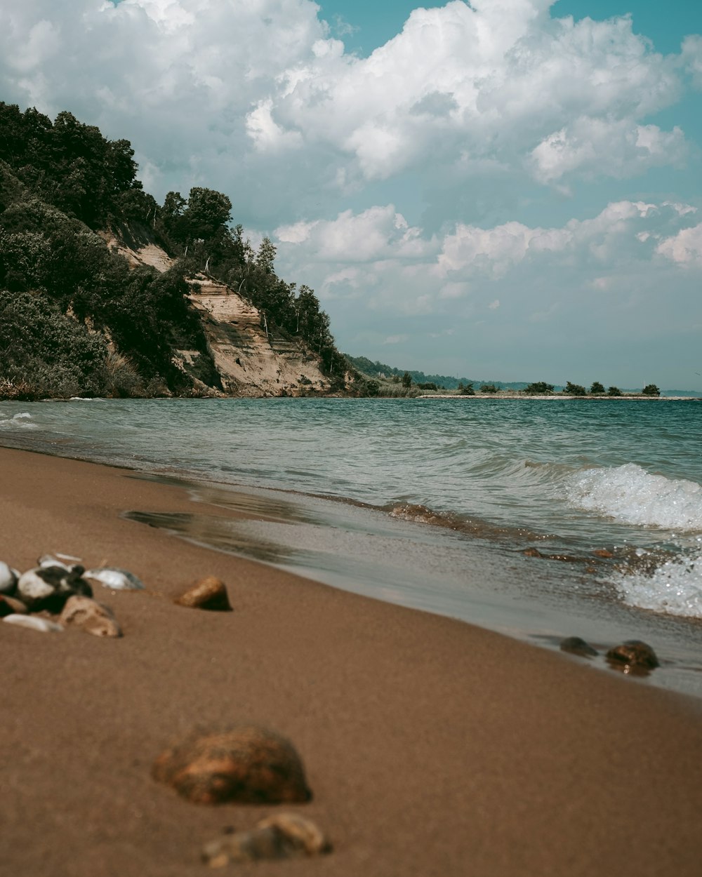 a sandy beach with waves coming in to shore