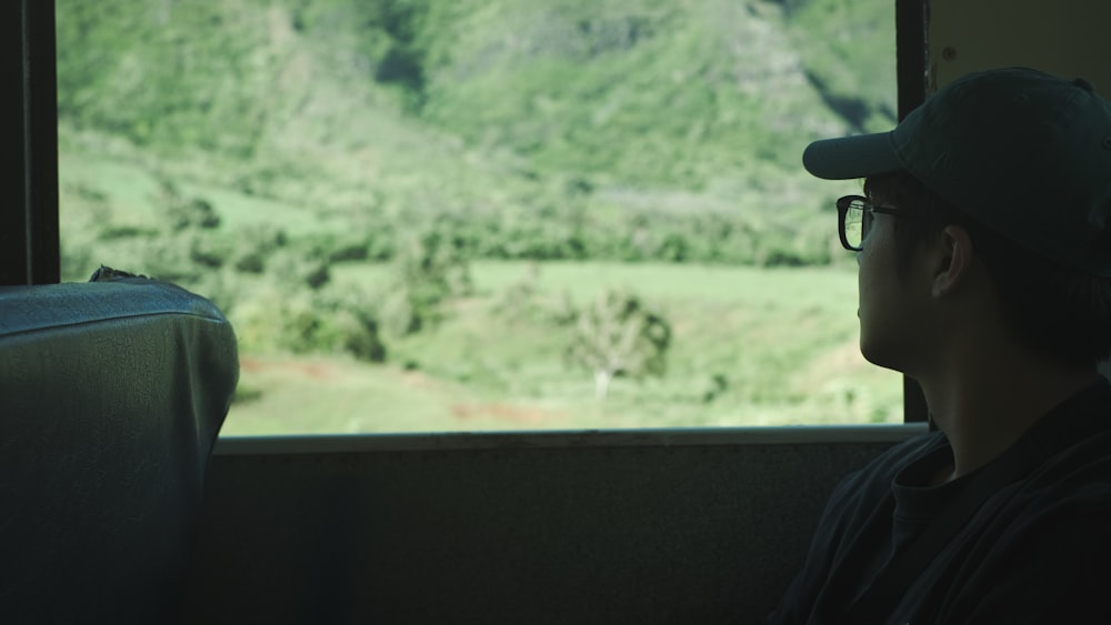 a man sitting on a train looking out the window