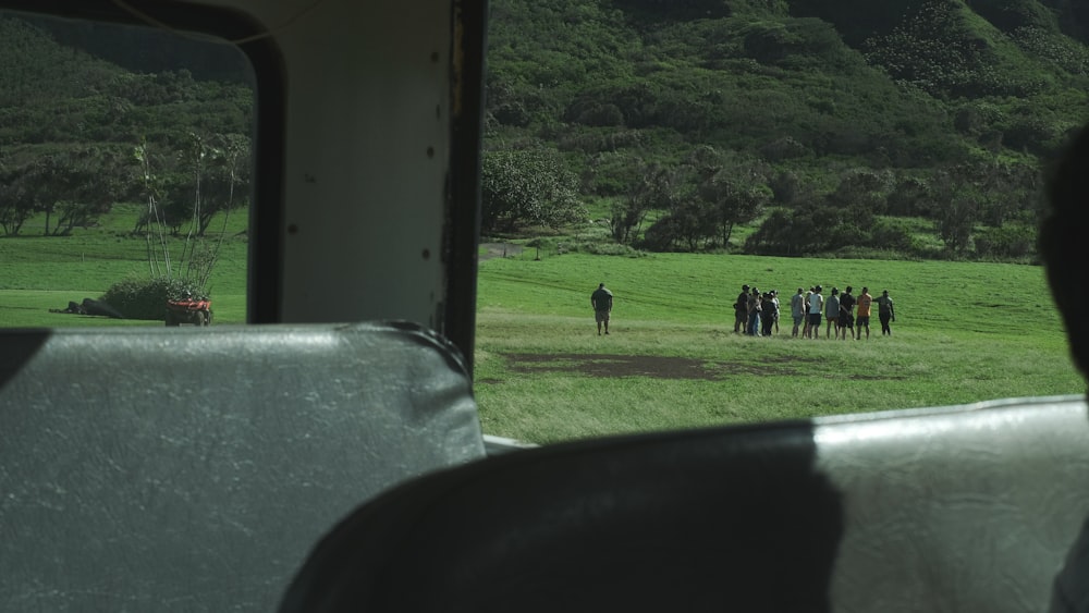 a group of people standing on a lush green field