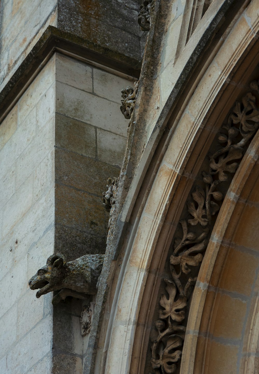 a close up of a stone building with a gargoyle on it