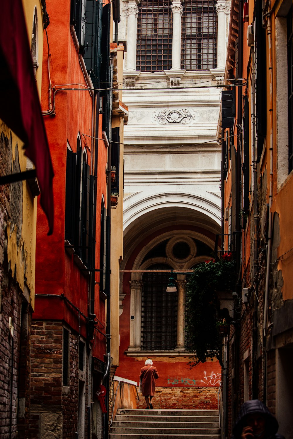 a narrow alleyway with a person walking down it