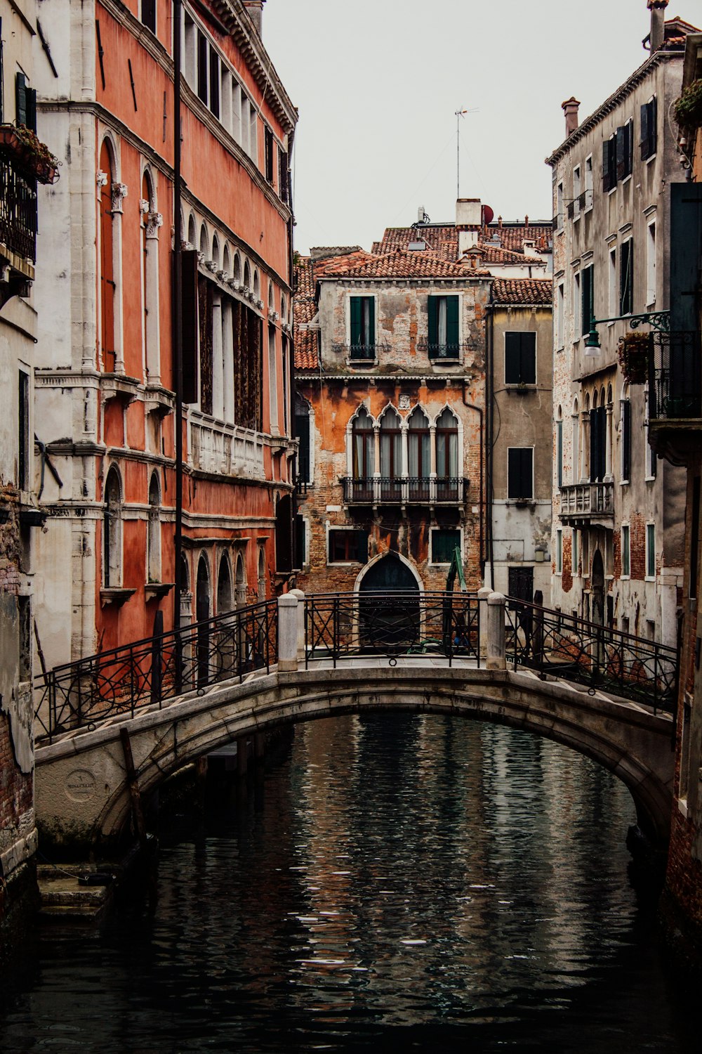 a bridge over a small canal in a city