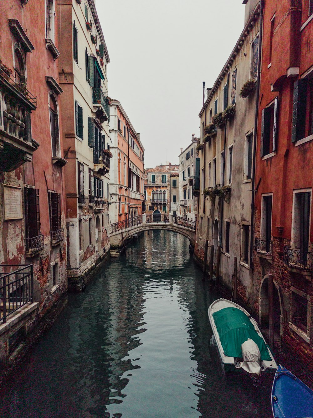 a boat floating down a river next to tall buildings