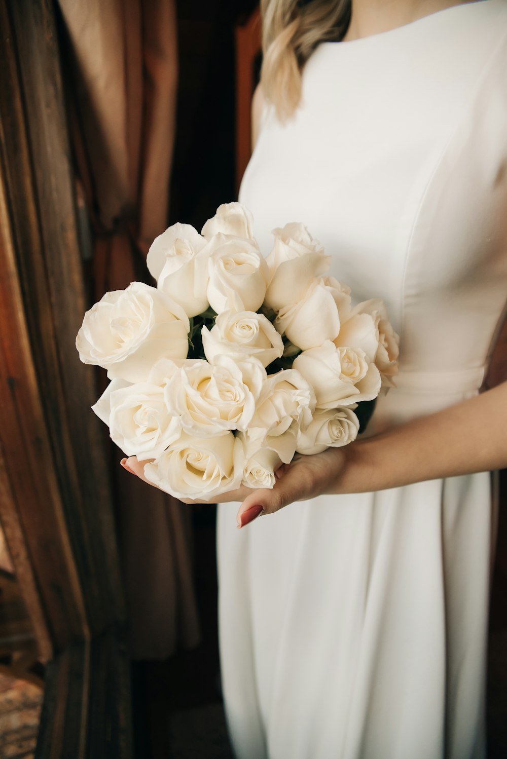 a woman in a white dress holding a bouquet of flowers