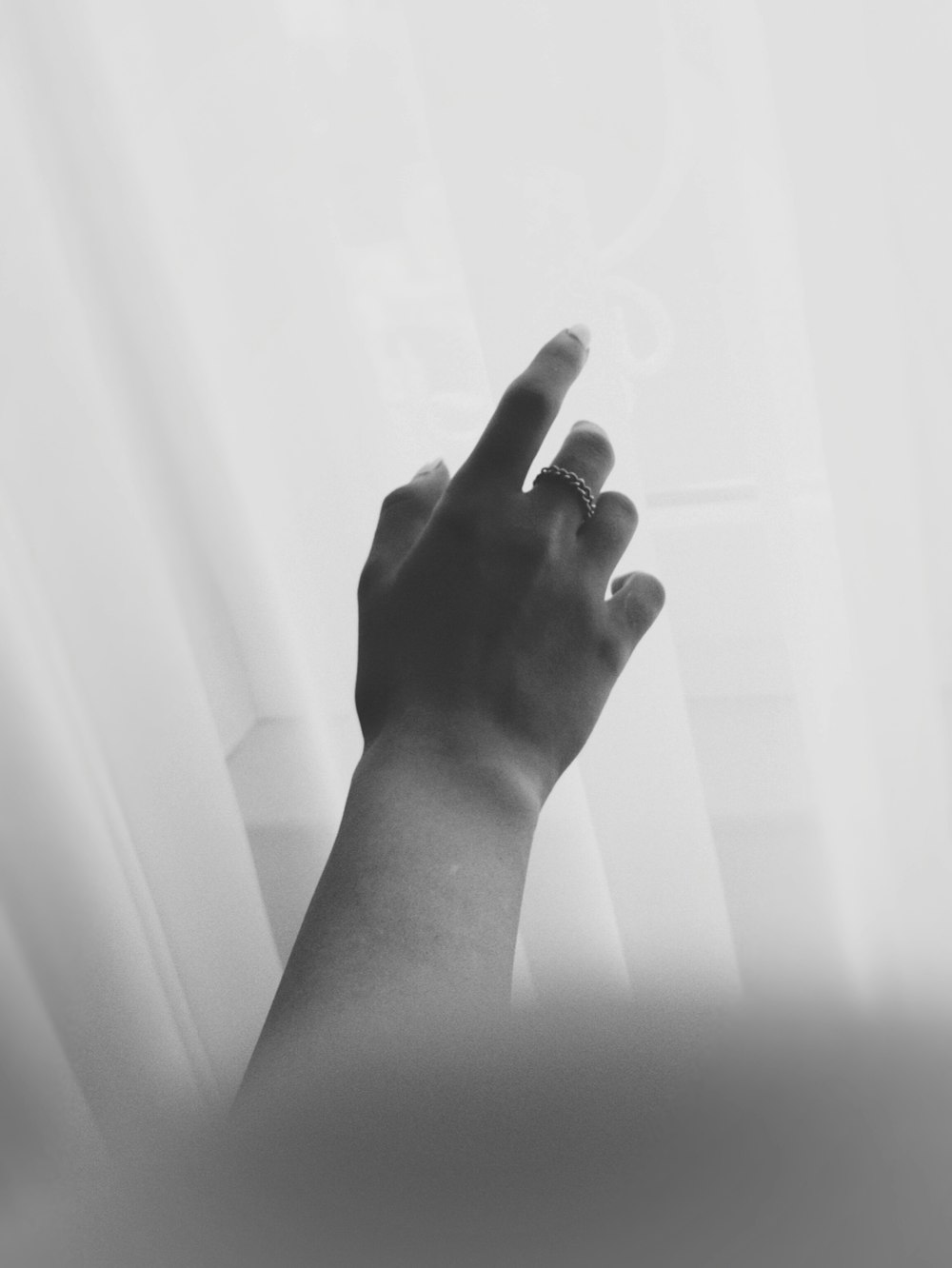 a person's hand reaching up towards a window