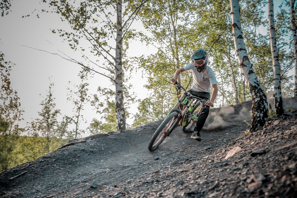 a man riding a bike down a dirt trail