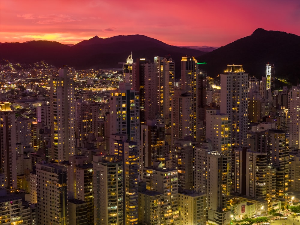 a view of a city at night with mountains in the background