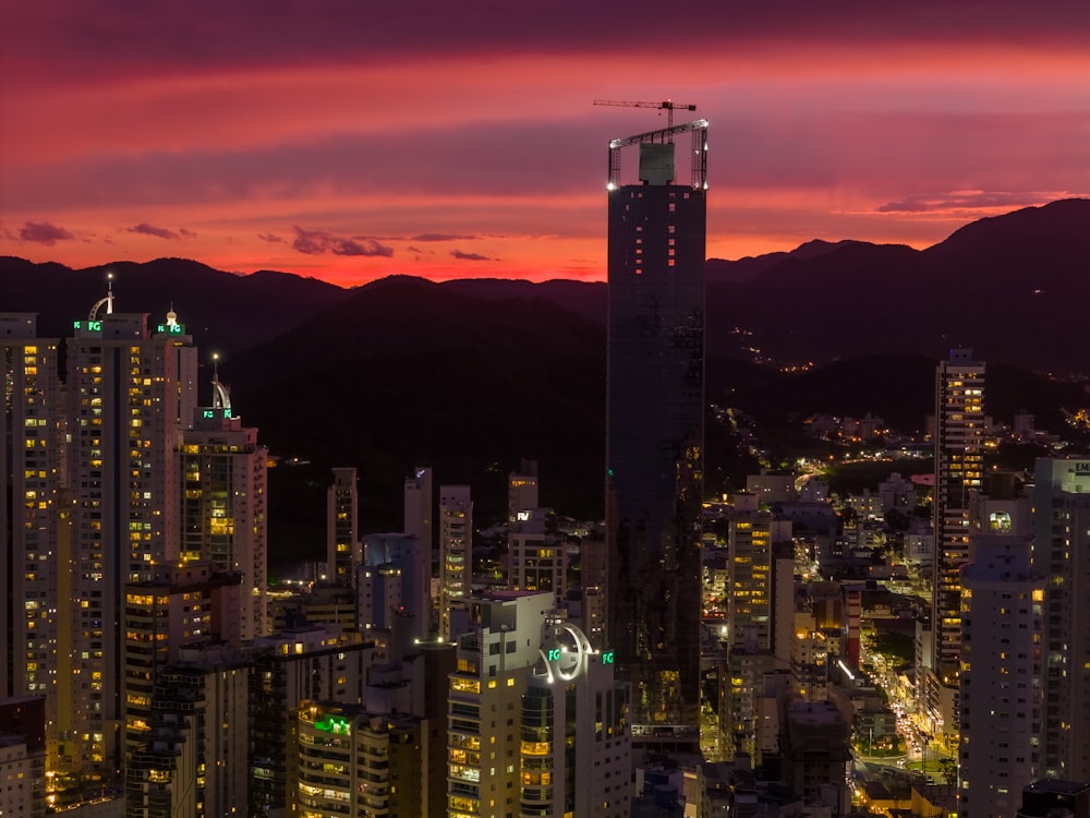 a view of a city at night with mountains in the background