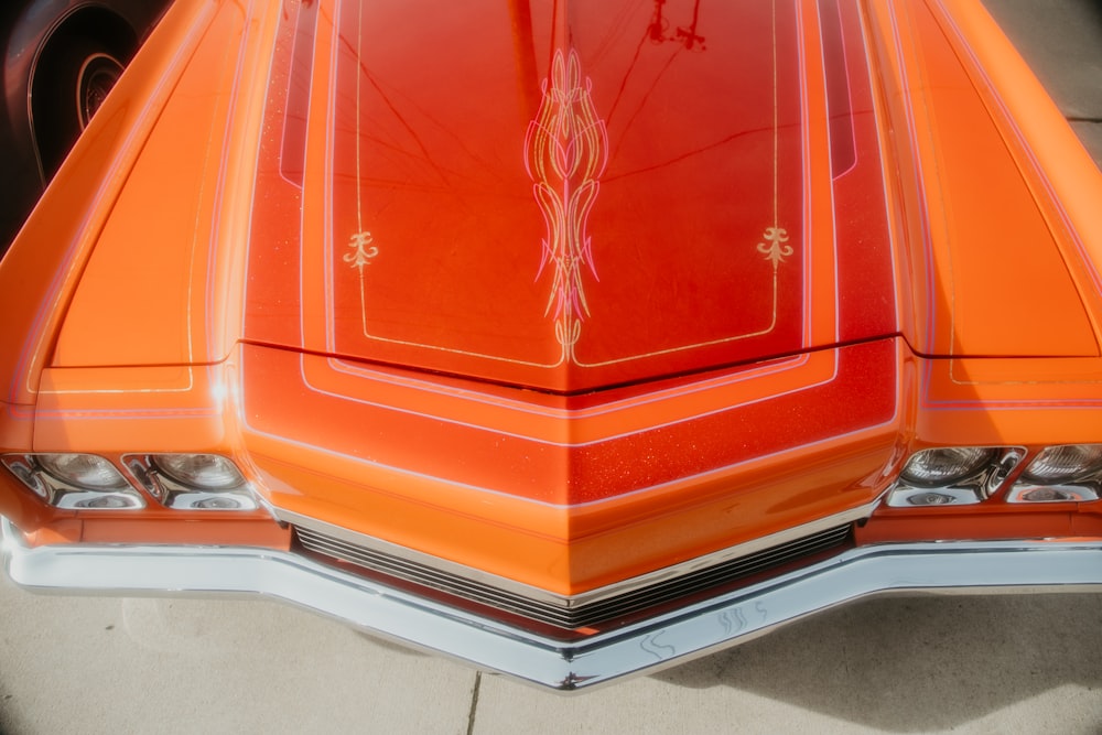 a close up of the hood of an orange car