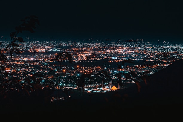 a view of a city at night from a hill
