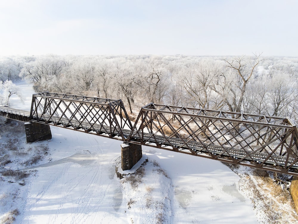 a train bridge over a snow covered river