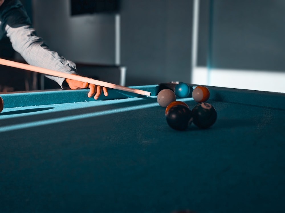 a pool table with a pool cue and balls on it