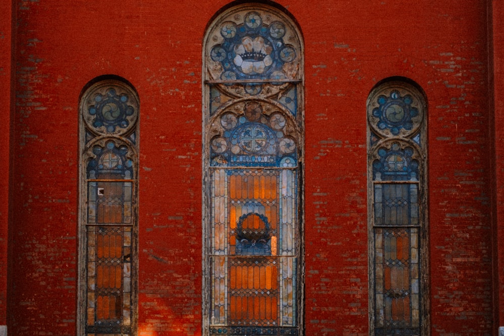 a red building with three windows and a clock