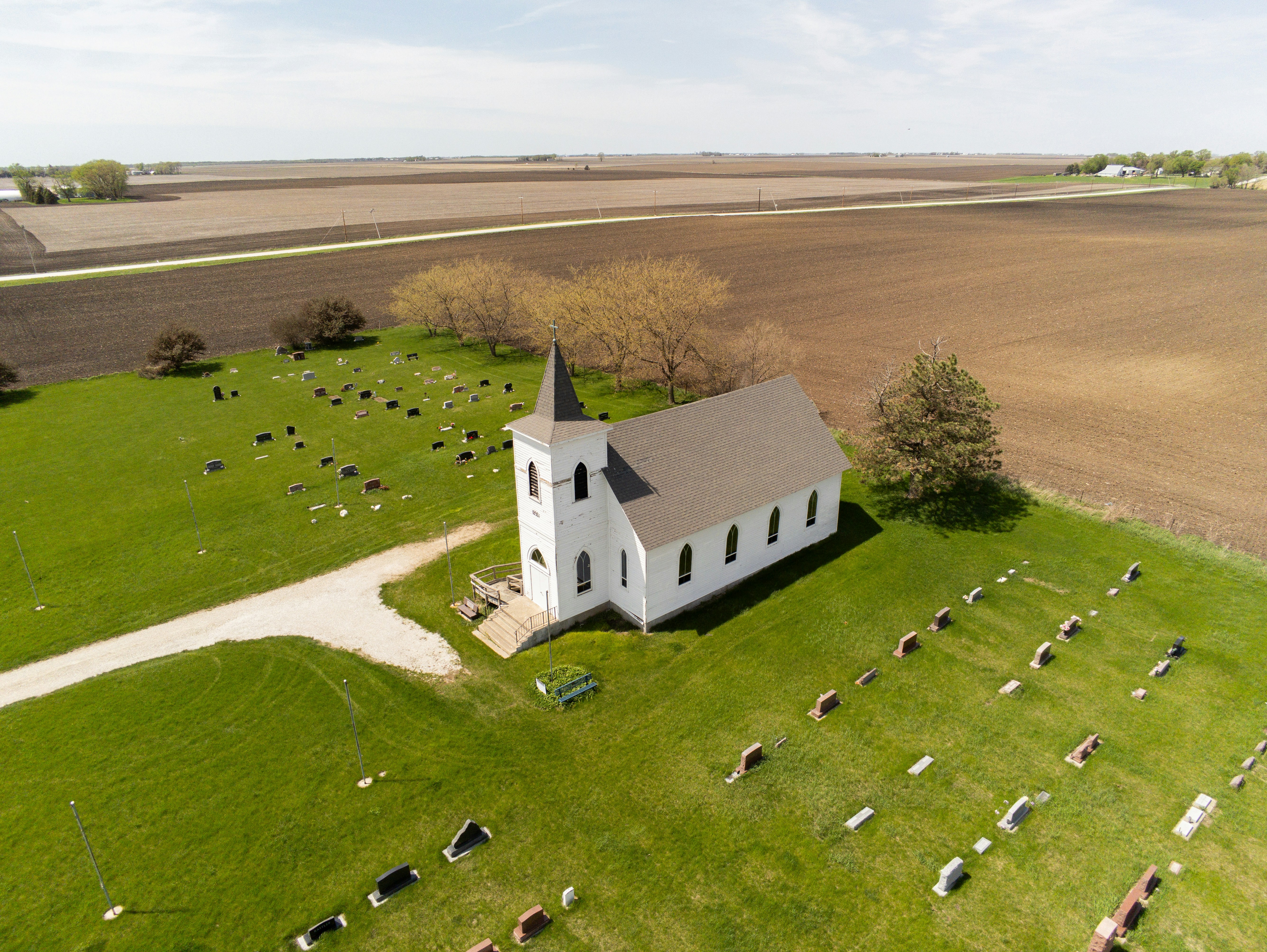 an aerial view of a church in a field