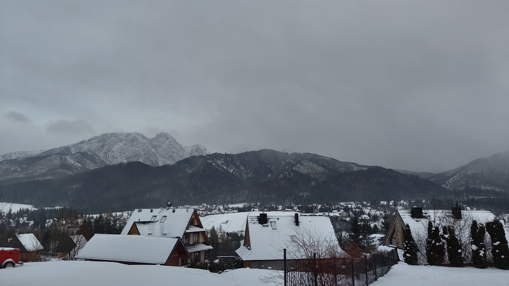 a snow covered town with mountains in the background