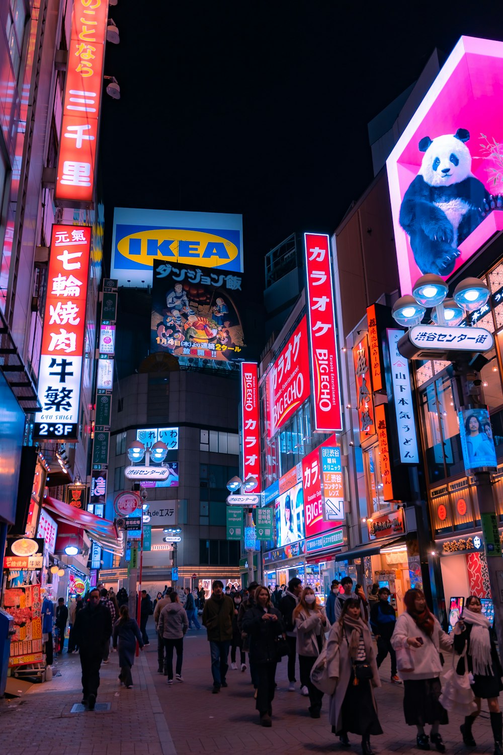 a crowded city street filled with lots of neon signs