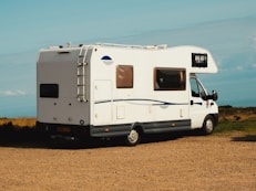 a small camper parked on a dirt road
