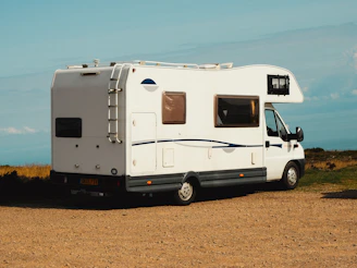 a small camper parked on a dirt road