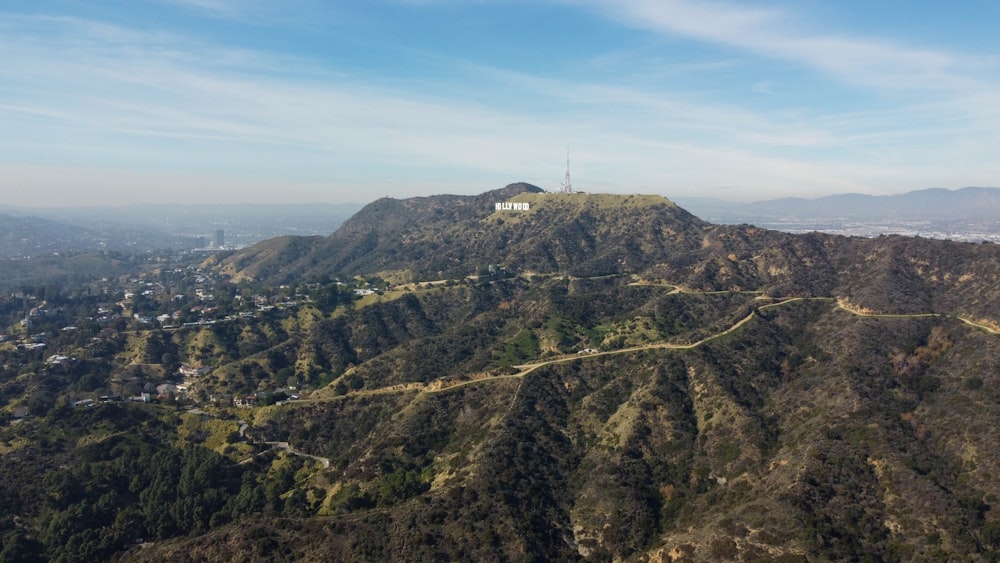 a scenic view of a mountain with a house on top