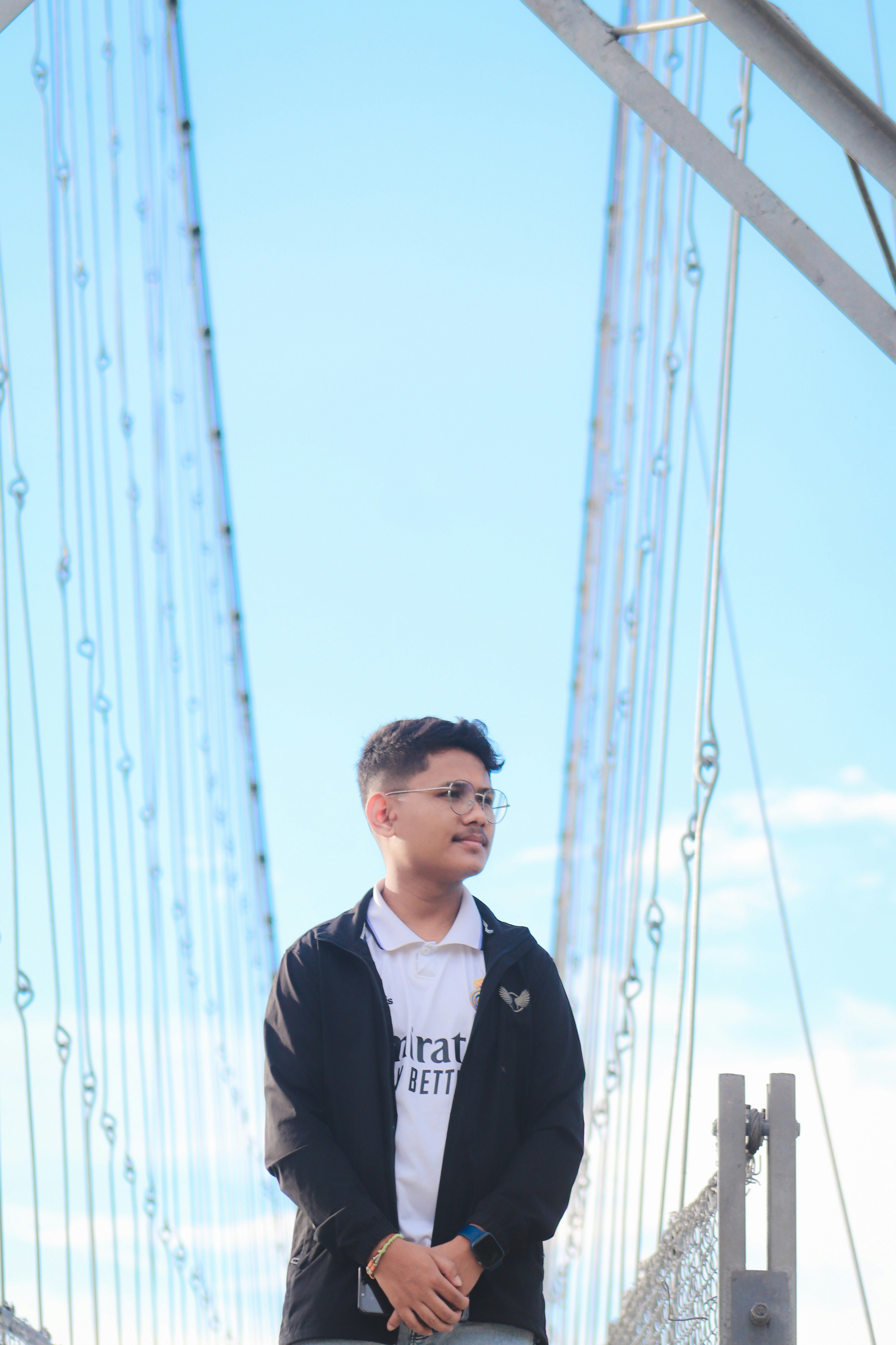 a man standing on a bridge with a skateboard