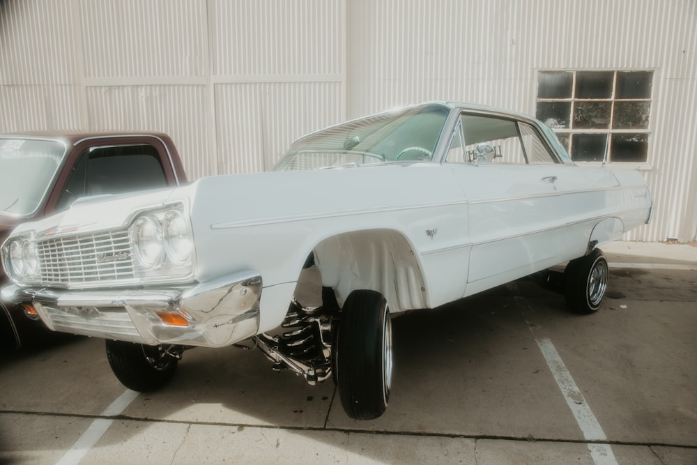 a white car parked in a parking lot next to a building