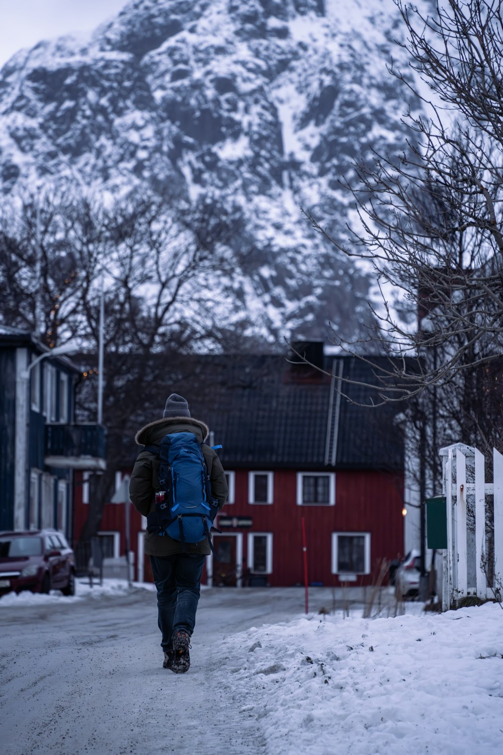 a person with a backpack walking down a snowy street