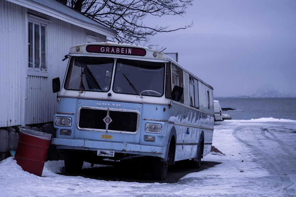 a blue bus parked in front of a white building