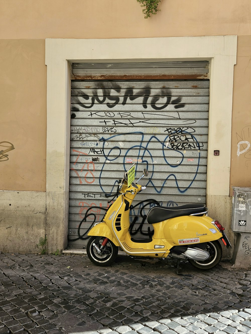 a yellow scooter parked in front of a garage door