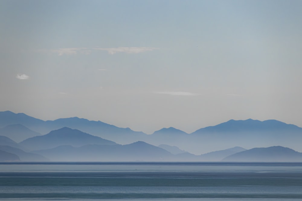 a large body of water with mountains in the background