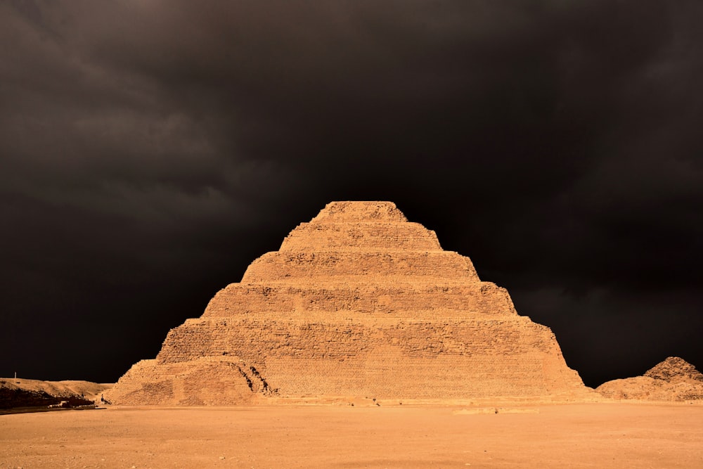 uma pirâmide muito alta sentada no meio de um deserto