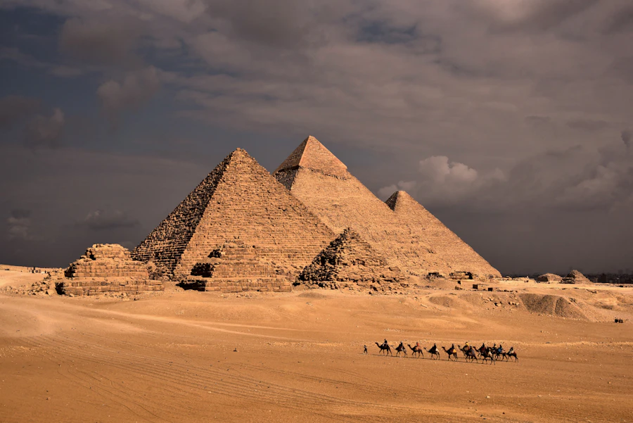 Caravana de camellos frente a las pirámides de Giza al atardecer