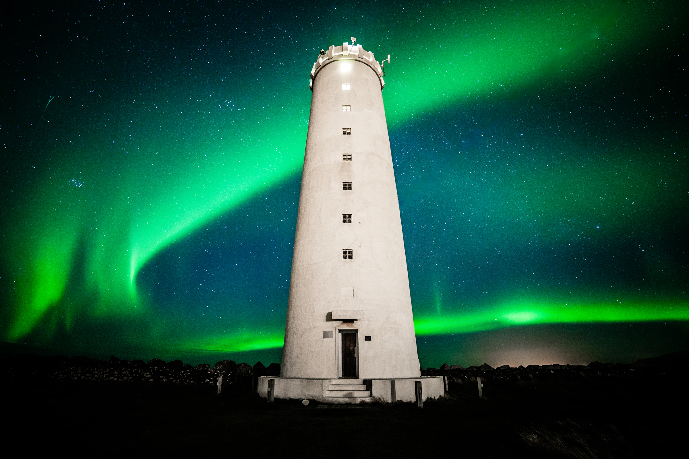 Seltjarnarnes lighthouse near Reykjavík under the green Northern Lights