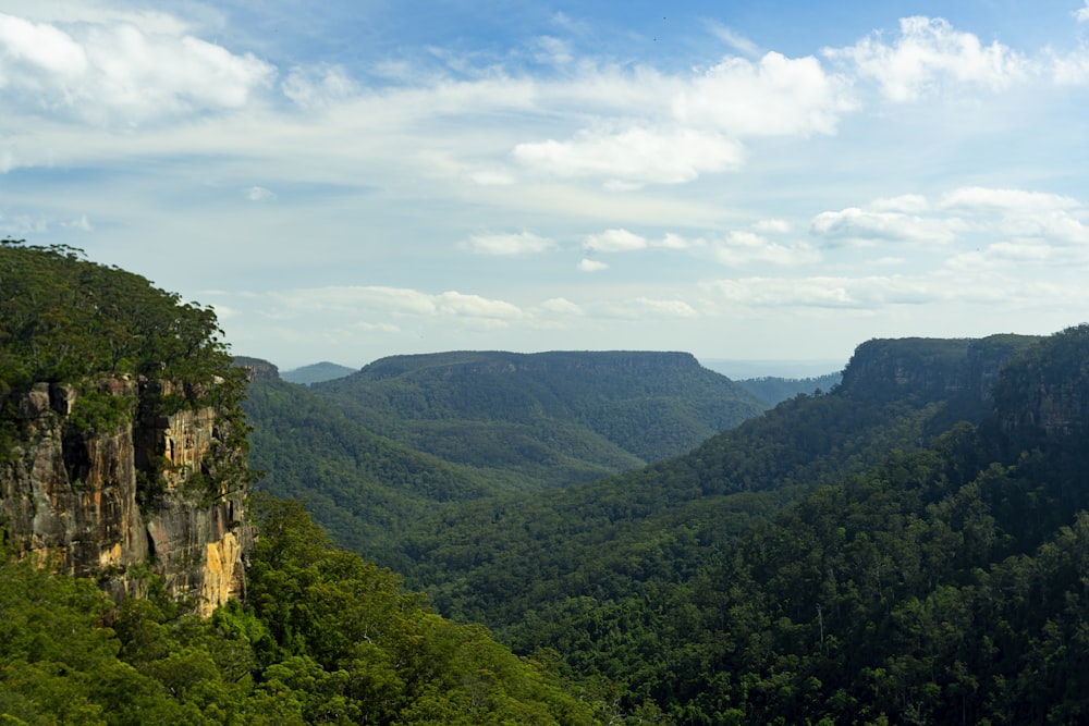 a view of a mountain range with trees and mountains in the background