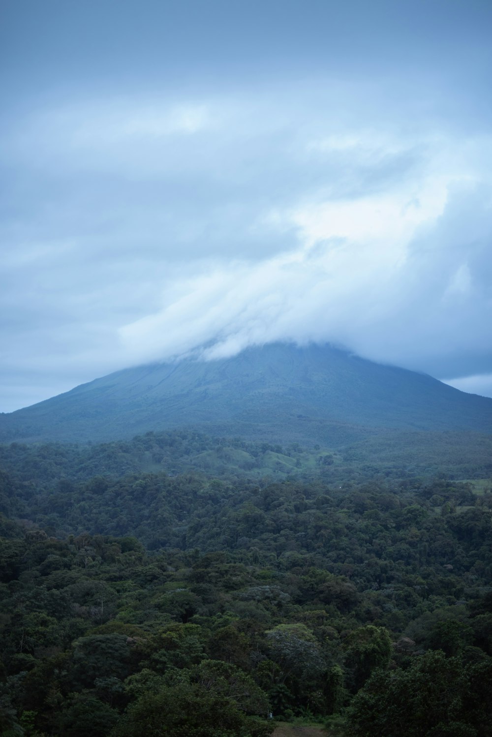 a very tall mountain with a cloud in the sky