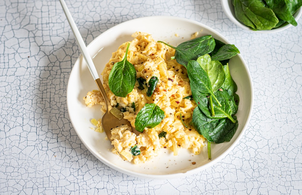 a white plate topped with eggs and spinach