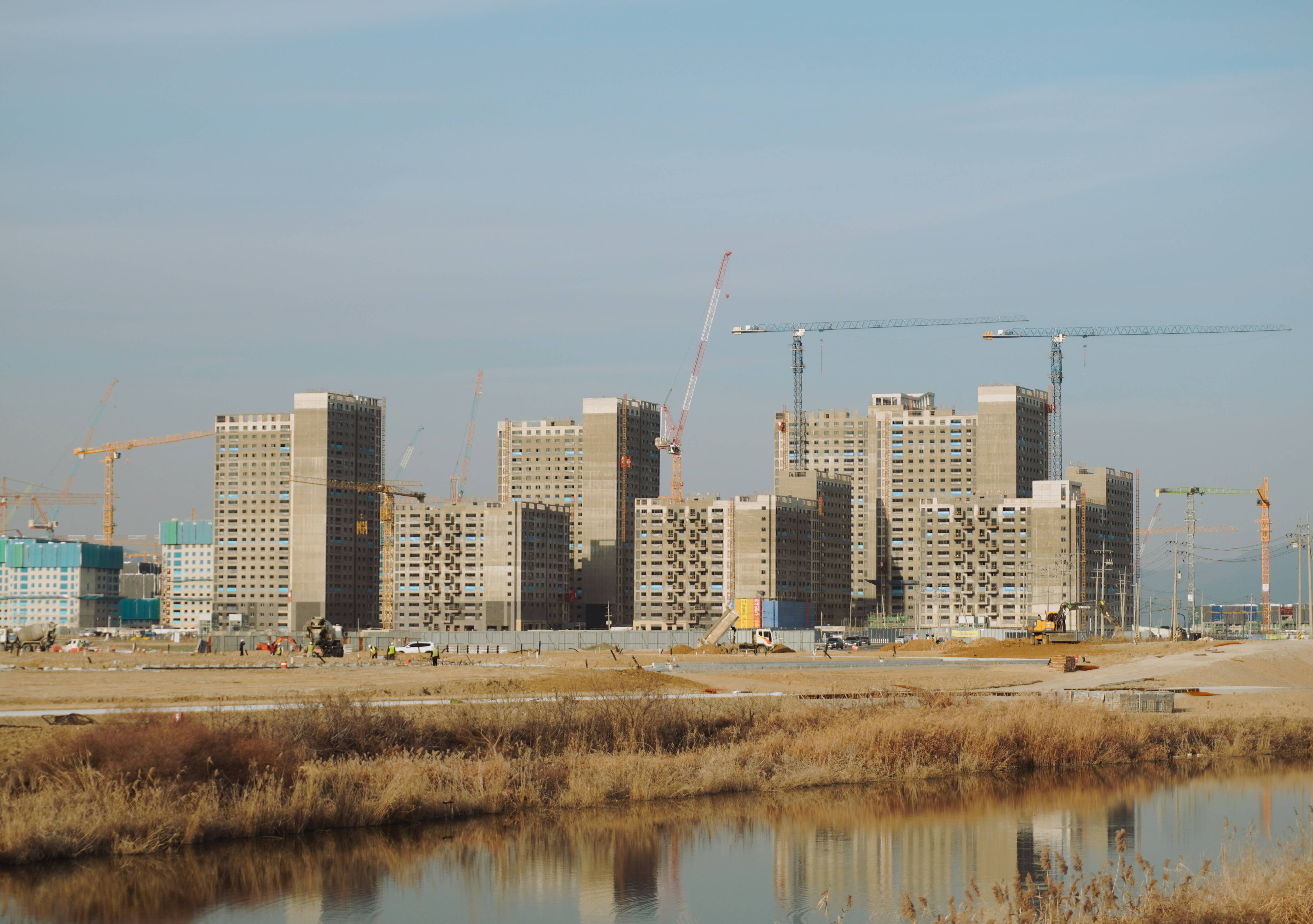 a construction site with a body of water in the foreground
