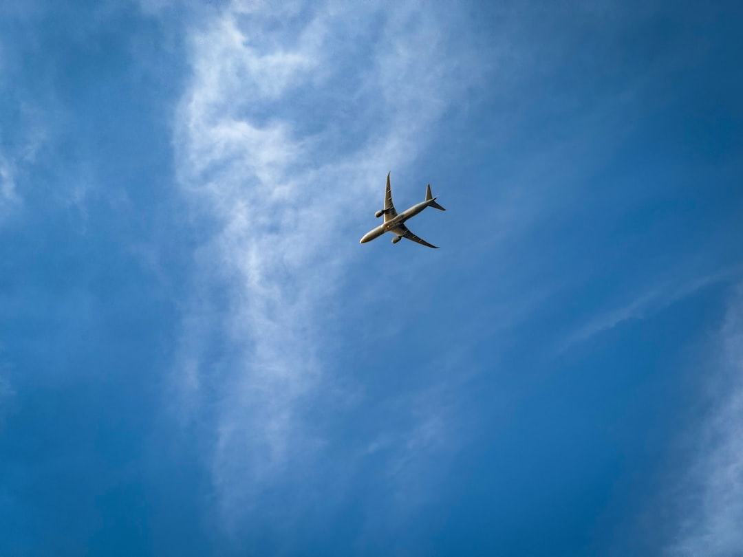 an airplane is flying through the blue sky,